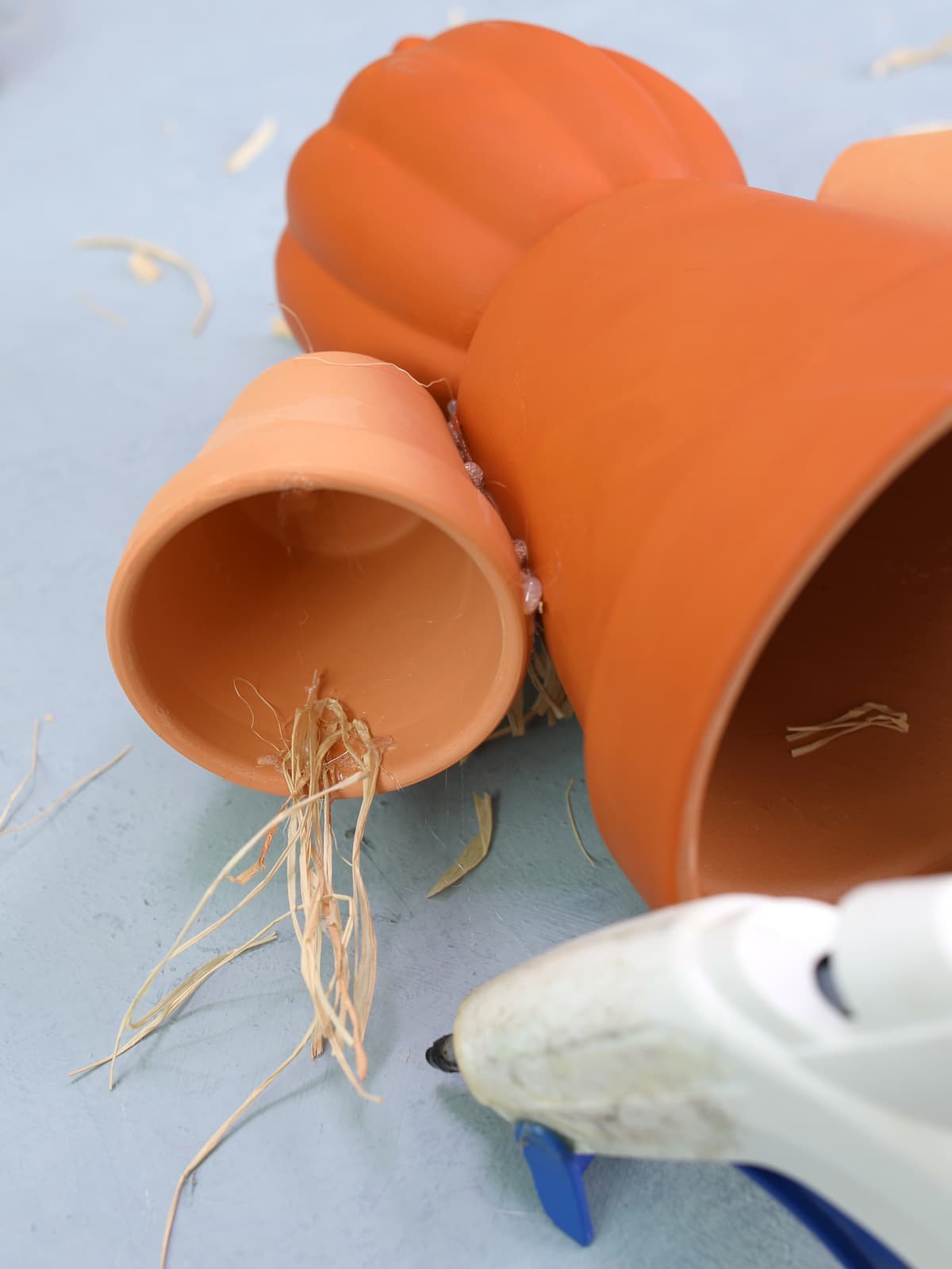 glue rafia to clay pot to make a scarecrow